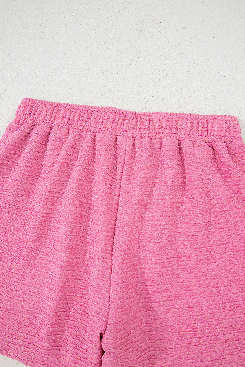 Easy, breezy, and totally put-together. This textured V-neck tee and shorts set in a soft pink is the matching set you'll want to live in all summer