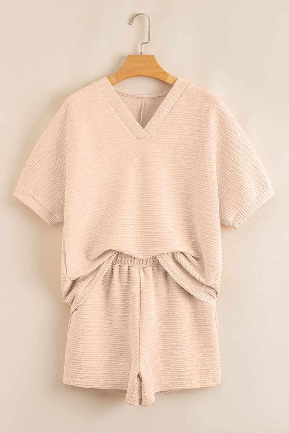 Warm tones, cool vibes. This textured V-neck tee and shorts set in a soft apricot is the matching set made for summe